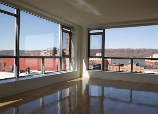 A large empty room with a view of the city.