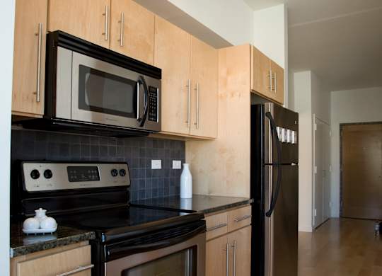 A kitchen with wooden cabinets and black appliances.