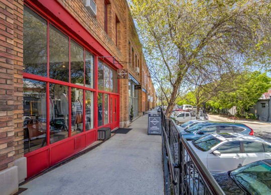 a brick building with a red exterior and a sidewalk in front of it