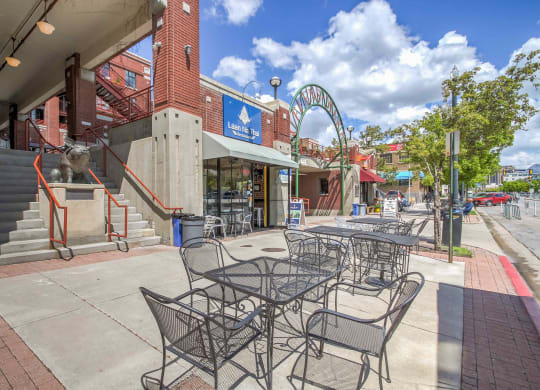 a patio with tables and chairs in front of a building