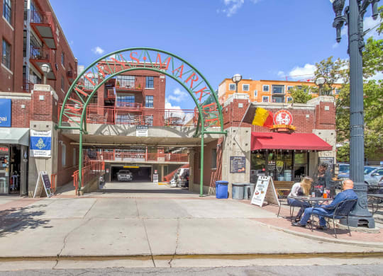 a city street with people sitting at tables in front of a building