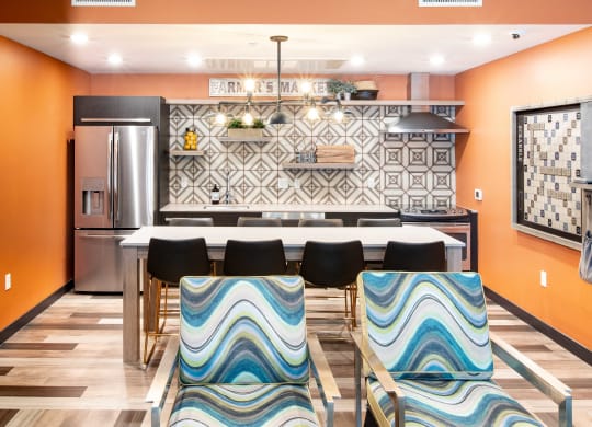 a kitchen with orange walls and a white table with blue and white chairs