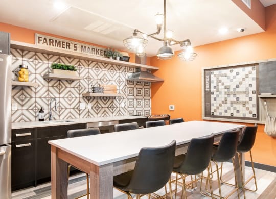 a kitchen with a large white table and black and white tiles on the wall