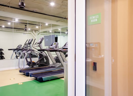 a gym with treadmills and a fitness room