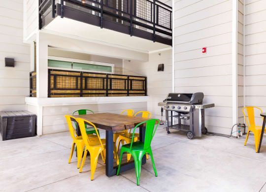 a patio with a table and chairs and a grill