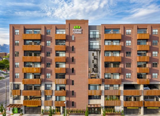a large apartment building with a green logo on the side of it