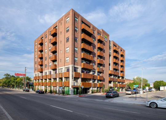 a large brick building with balconies on a city street