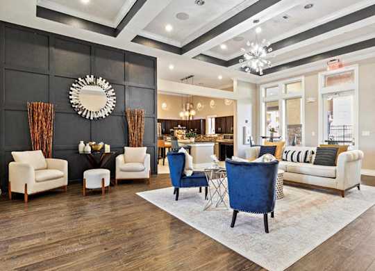 A living room with a blue chair in the center and a mirror on the wall.