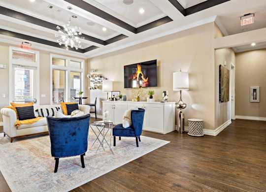A living room with a blue chair and a white sofa.