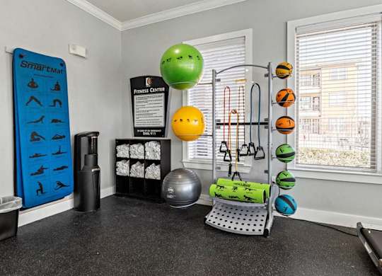 A room with a SmartFit wall hanging and a variety of exercise equipment.