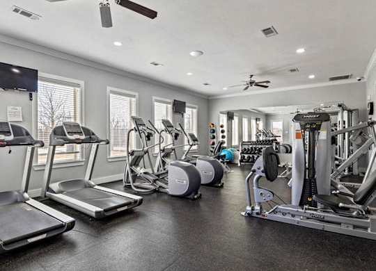 A spacious gym with treadmills, elliptical machines, and other exercise equipment.