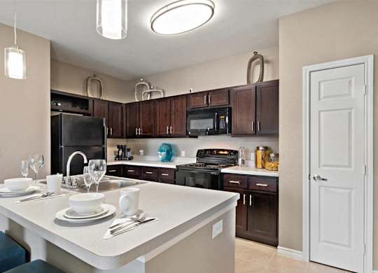 A kitchen with brown cabinets and black appliances.