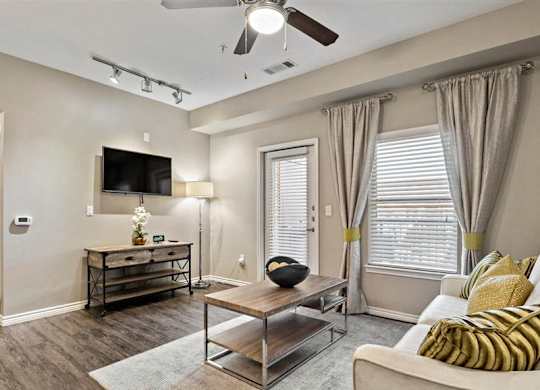 A living room with a white couch and a wooden coffee table.