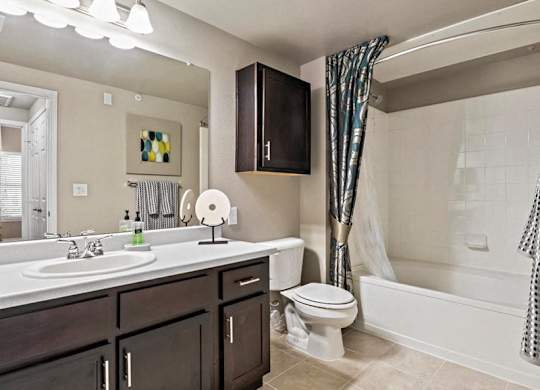 A bathroom with a white sink, toilet, and bathtub.