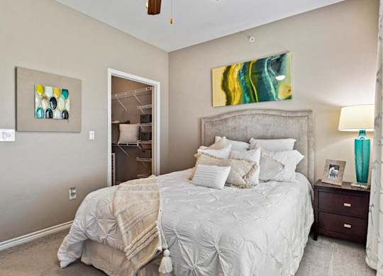 A bedroom with a large bed and a ceiling fan.