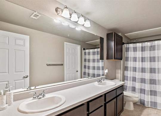 A bathroom with a sink, mirror, and shower curtain.