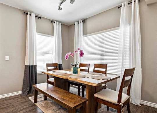 A dining room with a wooden table and chairs.