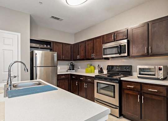 A kitchen with brown cabinets and a white counter.