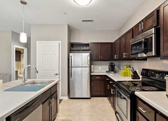 A kitchen with brown cabinets and a white counter.
