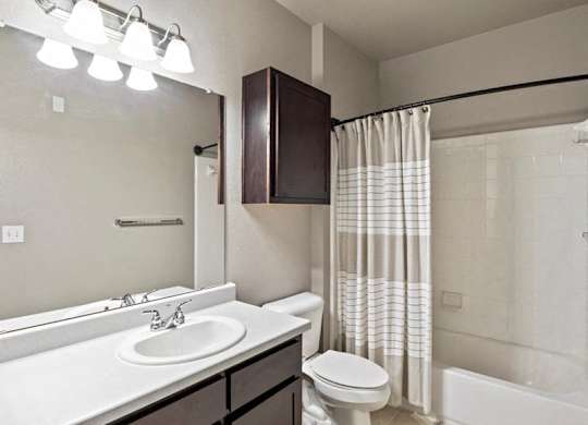 A bathroom with a white sink and a white toilet.