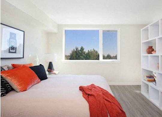 Comfortable Bedroom with White Bookcase, carpeted flooring, and large windows at Arabella Apartment Homes, Shoreline, WA, 98155