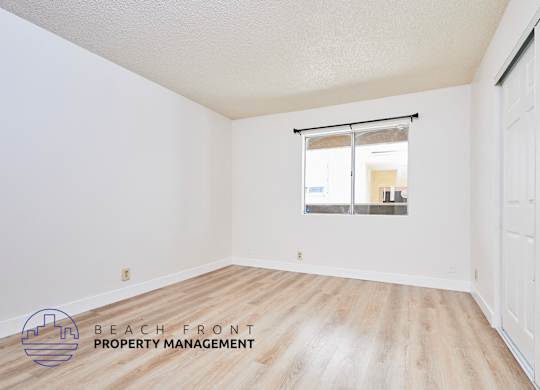 A room with a window and a logo for Beach Front Property Management.