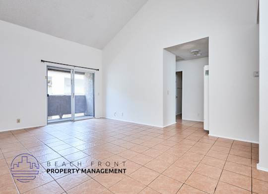 A spacious room with a logo for Beach Front Property Management on the floor.