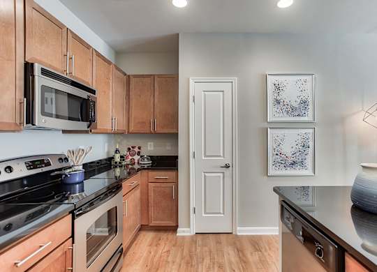 a kitchen with wood cabinets and black countertops