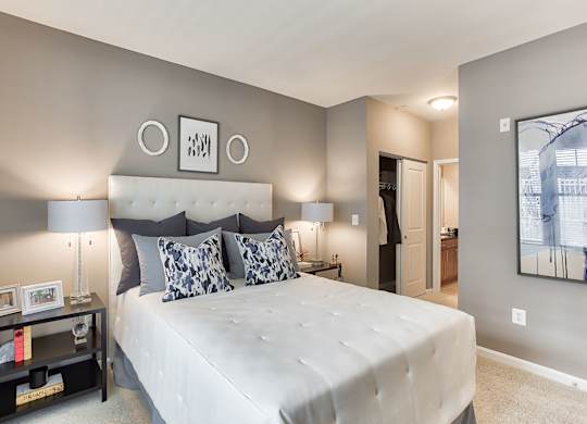 a bedroom with a large bed and two nightstands with lamps