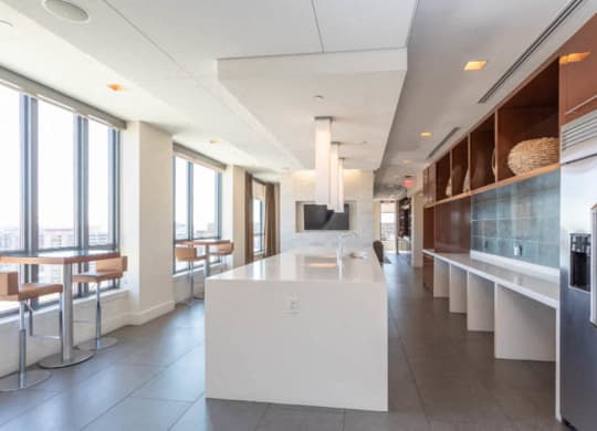 club kitchen with a long counter and a large window at The Millennium, Virginia, 22202