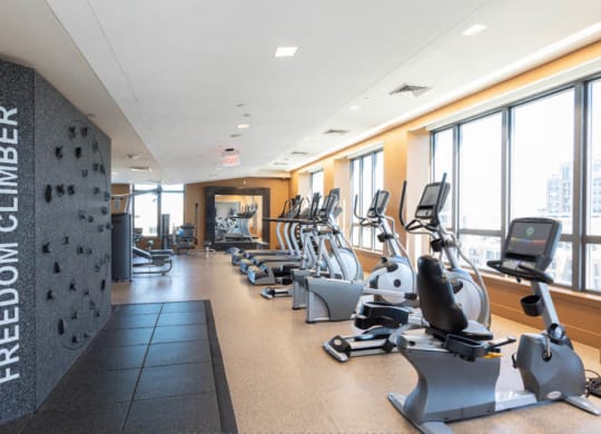 a room filled with cardio equipment and large windows at The Millennium, Virginia, 22202
