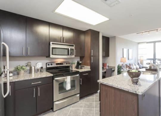 a kitchen with dark cabinets and granite countertops at The Millennium, Arlington, VA
