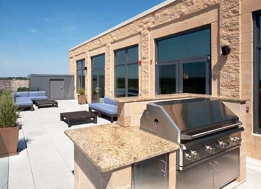 a patio with a grill and lounge chairs at The Millennium, Virginia, 22202