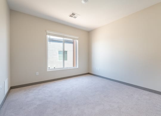 Bedroom with carpet and large window and blinds