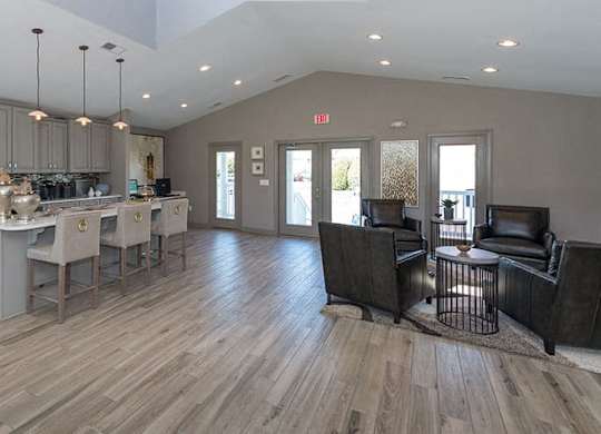 clubroom with vaulted ceilings, gray cabinets and an island with stools