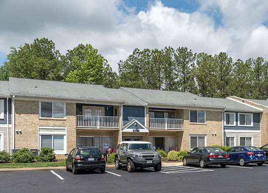 exterior roadway showing parking spots and cars in front of the building