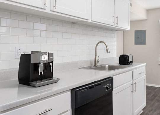 apartment kitchen with white cabinets and black appliances