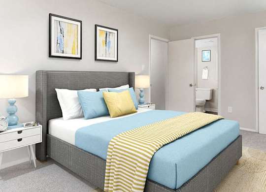 bedroom of the apartment showing queen bed with artwork and attached bathroom
