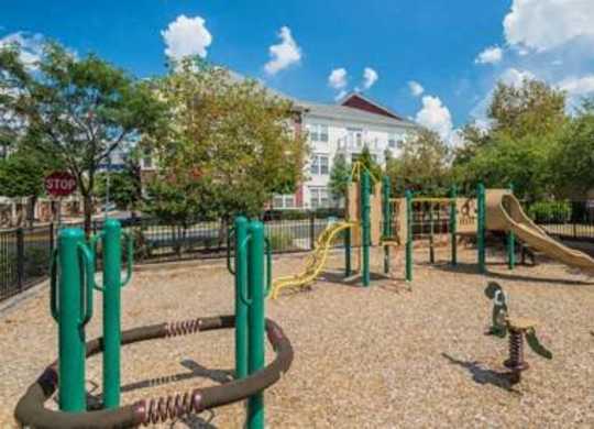 a playground at a park with trees and a building