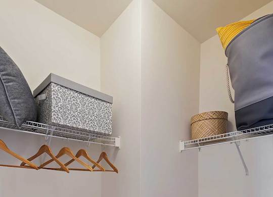 a closet with shelves and pillows in a corner