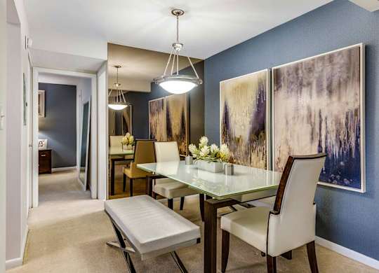 a dining room with a glass table and chairs
