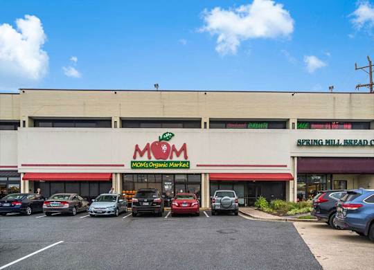 the front of a supermarket with cars parked in the parking lot