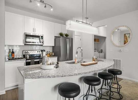 a kitchen with an island with black stools