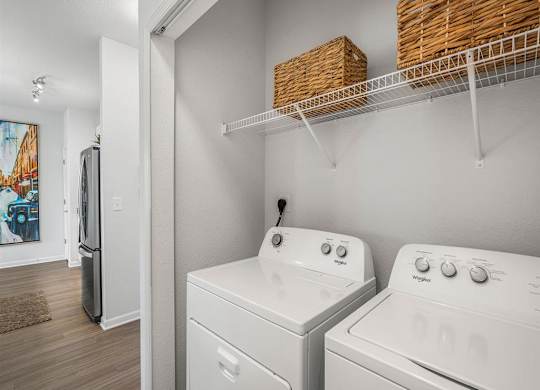 a white laundry room with two washes and a dryer