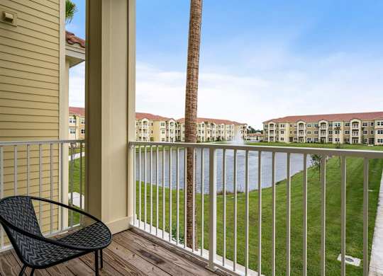 a balcony with a chair and a palm tree