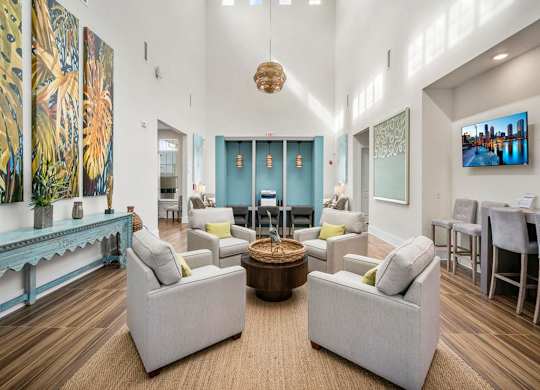 A lobby with a large painting on the wall and a TV mounted on the wall.