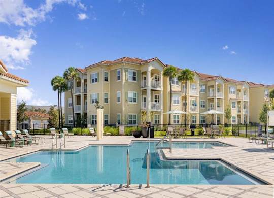 A large apartment complex with a pool in the foreground.