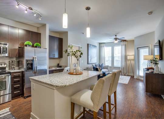 A modern kitchen with a center island and stainless steel appliances.