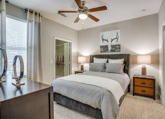 Large bedroom with carpet flooring, natural light, ceiling fan