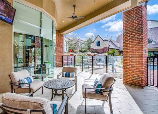 Outdoor lounge seating and grilling area at pool